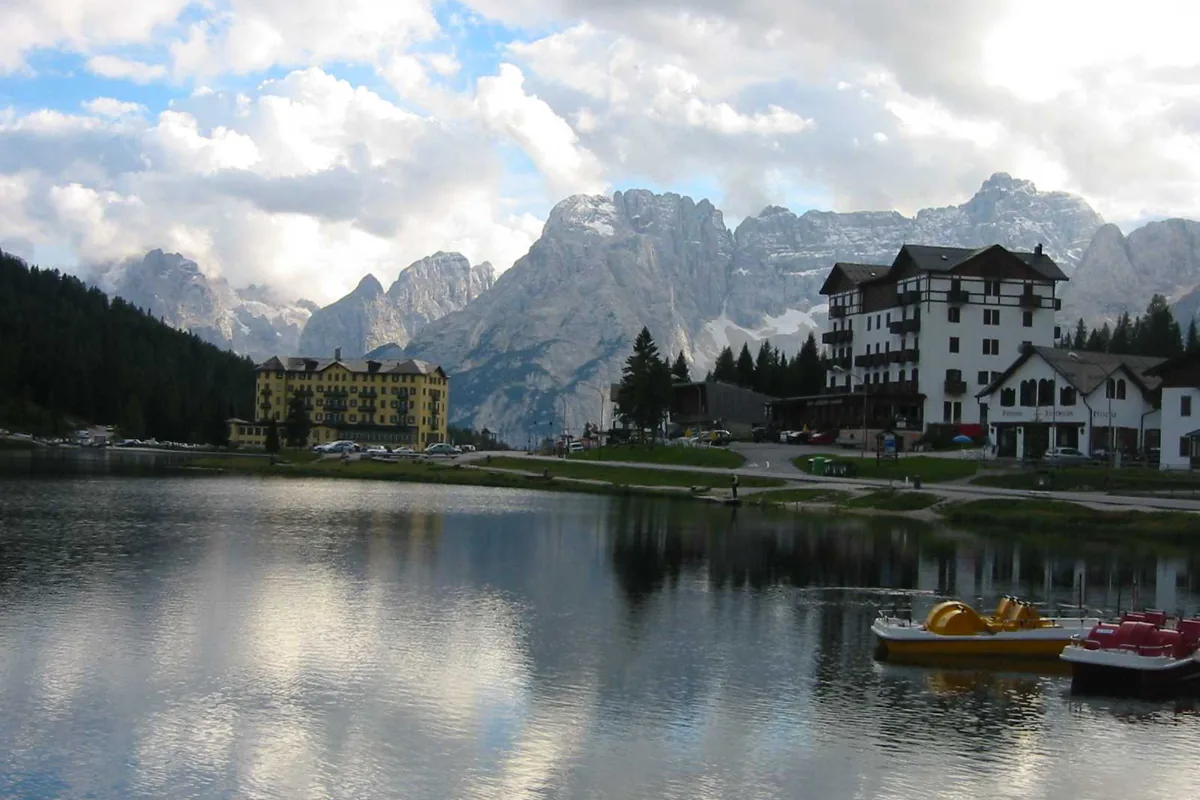 Jezero Misurina odrážející vrcholy Dolomit pod jasnou oblohou